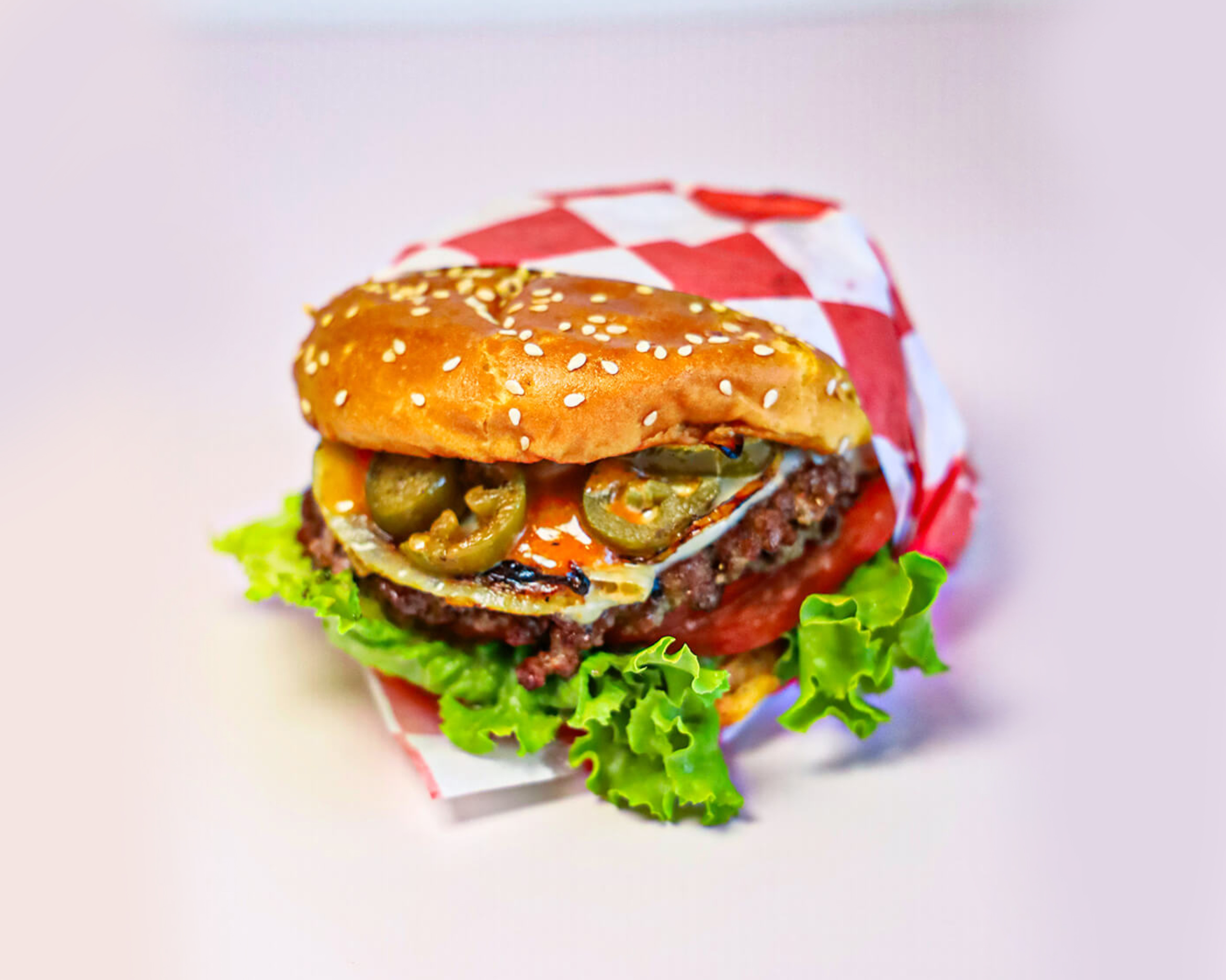 Gangnam Spicy Burger with jalapeños, lettuce, and sauce at No Idea Burger Joint in Norcross